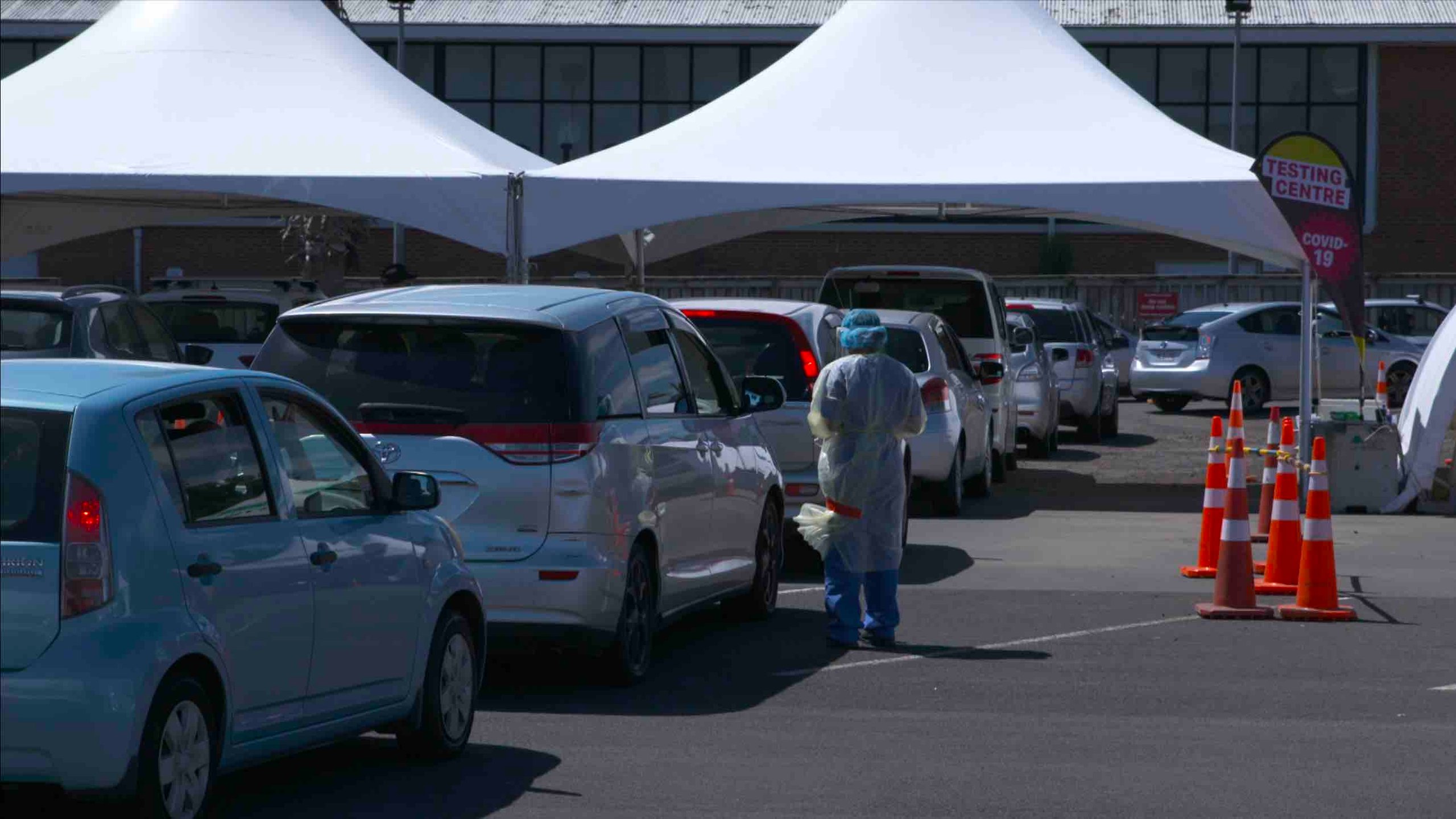 cars lined up at an auckland covid-19 testing station