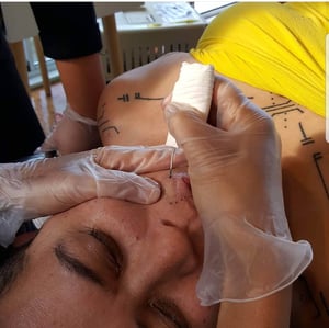 Luisa Tora receiving her marks from Papua New Guinean mark-maker, Julia Mage-au Gray. Photo: Molly Rangiwai-McHale