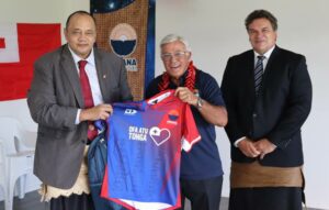 Tuifa'asisina Sir Bryan Williams presents Prime Minister Hu'akavameiliku with Moana Pasifika’s Heritage Jersey signed by the entire team with chair Sir Michael Jones. Photo: Supplied